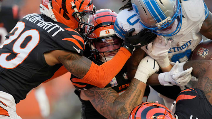 Cincinnati Bengals cornerback Cam Taylor-Britt (29), left, Bengals linebacker Logan Wilson (55) and Bengals safety Geno Stone (22) try to take down Detroit Lions running back Jahmyr Gibbs (0) in the 3rd quarter at Paycor Stadium on October 5, 2025. The Bengals lost 24-37.