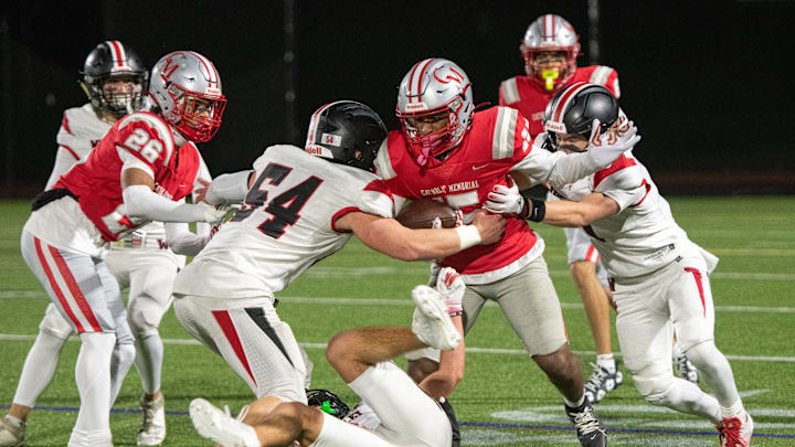 Wellesley junior captain Brandon Hollingsworth (54, left) and junior captain Matthew Leibman (right) combine their efforts to bring down Catholic Memorial junior Isaiah Simmons during the Division 2 state semifinals game at Weston High, Nov. 22, 2024. The Knights defeated the Raiders, 49-7.