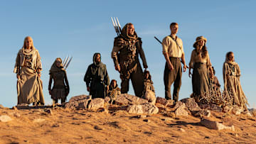 A group of Aiel with Rand (Josha Stradowski), Moiraine (Rosamund Pike) and Lan (Daniel Henney), which includes Bair (Nukâka Coster-Waldau) and Rhuarc (Björn Landberg).