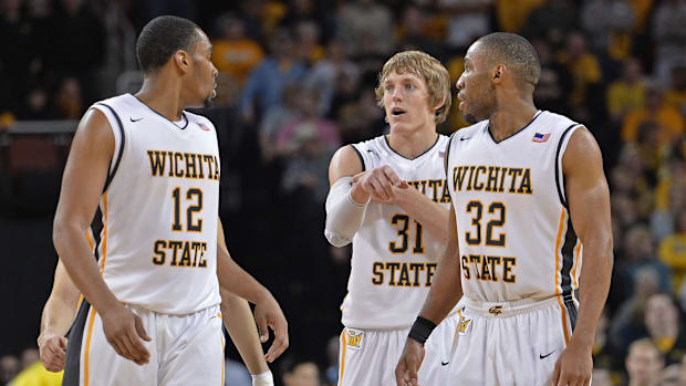 Wichita State Shockers guard Ron Baker talks with teammates Tekele Cotton and Darius Carter.