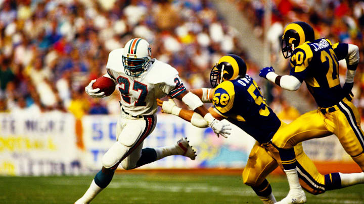 Mel Owens (58) of the Rams chases Lorenzo Hampton of the Dolphins.