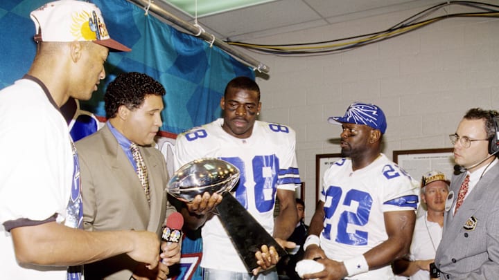 NBC sportscaster Greg Gumble with Dallas Cowboys stars Emmitt Smith, Larry Brown, and Michael Irvin with the Lombardi Trophy. NBC sportscaster Greg Gumble with Dallas Cowboys stars Emmitt Smith, Larry Brown, and Michael Irvin with the Lombardi Trophy.