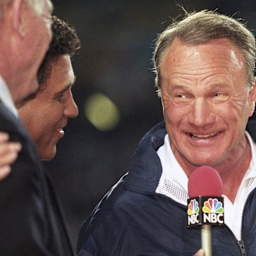 Dallas Cowboys head coach Barry Switzer holds the Lombardi trophy while talking to NBC sportscaster Greg Gumbel after a victory against the Pittsburgh Steelers in Super Bowl XXX 