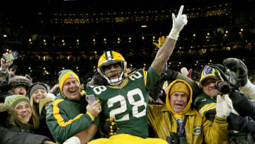 Green Bay Packers running back A.J. Dillon celebrates with a Lambeau Leap after scoring a touchdown.