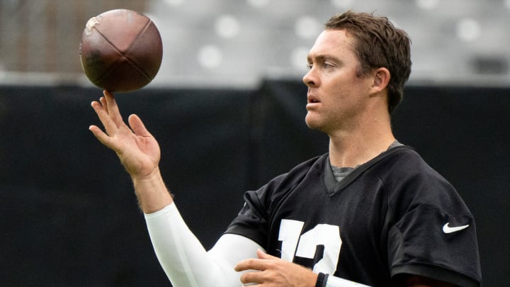 QB Colt McCoy spins a football during training camp.