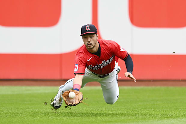 Steven Kwan dives for a ball in left field 