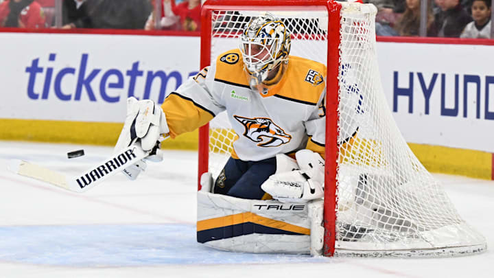 Apr 12, 2024; Chicago, Illinois, USA; Nashville Predators goaltender Kevin Lankinen (32) uses his stick to turn away a shot from the Chicago Blackhawks in the second period at United Center. Mandatory Credit: Jamie Sabau-Imagn Images