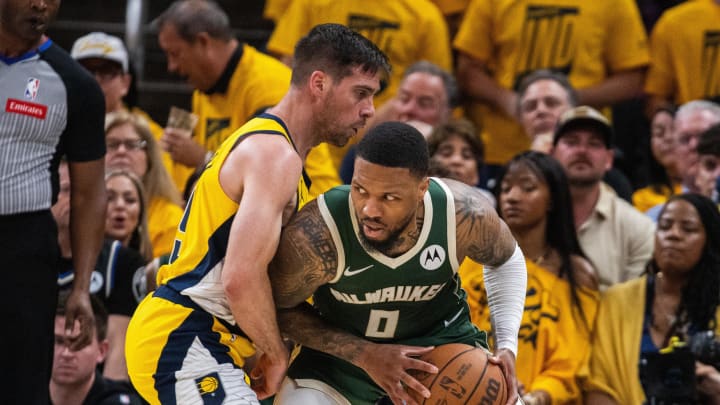 Milwaukee Bucks guard Damian Lillard (0) holds the ball while Indiana Pacers guard T.J. McConnell (9) defends during a 2024 NBA playoff game. 