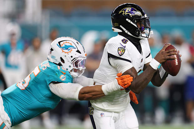 30 de octubre de 2025; Jardines de Miami, Florida, Estados Unidos; El mariscal de campo de los Baltimore Ravens, Lamar Jackson (8), es abordado por el lineba de los Miami Dolphins