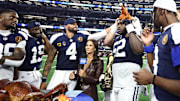 Nov 27, 2025; Arlington, Texas, USA; Dallas Cowboys quarterback Dak Prescott (4) and Dallas Cowboys guard Tyler Booker (52) celebrate with a turkey after the game against the Kansas City Chiefs at AT&T Stadium. Mandatory Credit: Kevin Jairaj-Imagn Images