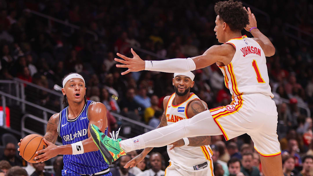 Nov 4, 2025; Atlanta, Georgia, USA; Orlando Magic forward Paolo Banchero (5) is defended by Atlanta Hawks guard Nickeil Alexander-Walker (7) and forward Jalen Johnson (1) in the second quarter at State Farm Arena. Mandatory Credit: Brett Davis-Imagn Images