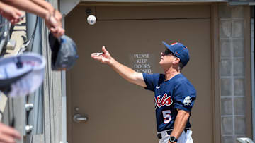 Jun 26, 2022; Omaha, NE, USA; Ole Miss Rebels head coach Mike Bianco tosses a ball to a fan before the game against the Oklahoma Sooners at Charles Schwab Field. Mandatory Credit: Steven Branscombe-Imagn Images