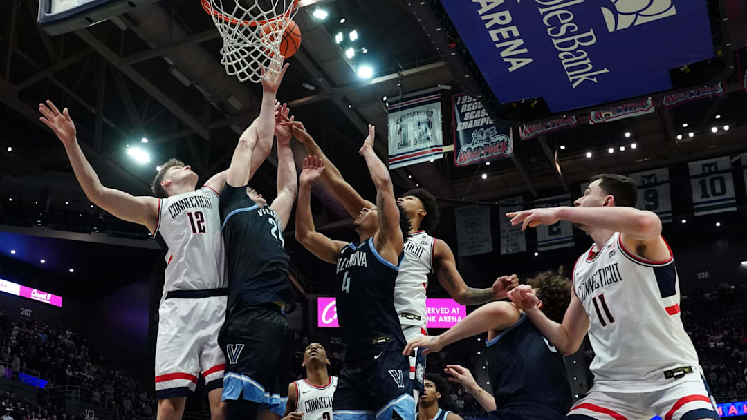 Jan 24, 2026; Storrs, Connecticut, USA; UConn Huskies center Eric Reibe (12) and forward Jaylin Stewart (3) work for the ball against Villanova Wildcats guard Tyler Perkins (4) and forward Duke Brennan (24) in the second half at Harry A. Gampel Pavilion. Mandatory Credit: David Butler II-Imagn Images