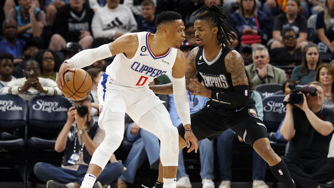 Mar 31, 2023; Memphis, Tennessee, USA; Los Angeles Clippers guard Russell Westbrook (0) dribbles as Memphis Grizzlies guard Ja Morant (12) defends during the first half at FedExForum. Mandatory Credit: Petre Thomas-Imagn Images