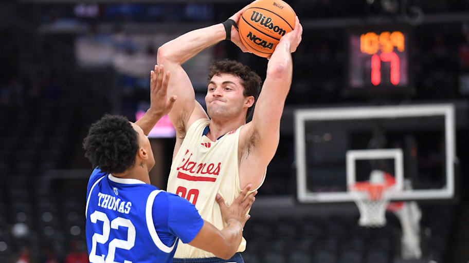 UIC guard Sam Silverstein looks to pass the ball over Drake guard Jaehshon Thomas during the MVC semifinal game.
