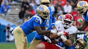 Nov 30, 2024; Pasadena, California, USA; UCLA Bruins linebacker Jalen Woods (17), defensive back Jaylin Davies (6), linebacker Carson Schwesinger (49), and UCLA Bruins defensive back Bryan Addison (4) tackle Fresno State Bulldogs tight end Jake Tarwater (87) during the third quarter at Rose Bowl. Mandatory Credit: Robert Hanashiro-Imagn Images