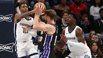 Dec 31, 2023; Memphis, Tennessee, USA; Memphis Grizzlies guard Ja Morant (12) and forward-center Jaren Jackson Jr. (13) defend Sacramento Kings forward Domantas Sabonis (10) as he drives to the basket during the second half at FedExForum. Mandatory Credit: Petre Thomas-Imagn Images
