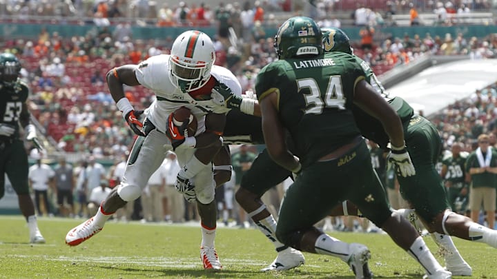 Sep 28, 2013; Tampa, FL, USA; Miami Hurricanes wide receiver Allen Hurns (1) runs with the ball as South Florida Bulls linebacker Reshard Cliett (16) defends during the first half at Raymond James Stadium. Mandatory Credit: Kim Klement-Imagn Images