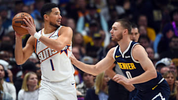 Oct 25, 2025; Denver, Colorado, USA; Phoenix Suns guard Devin Booker (1) is defended by Denver Nuggets guard Christian Braun (0) during the first half at Ball Arena. Mandatory Credit: Christopher Hanewinckel-Imagn Images