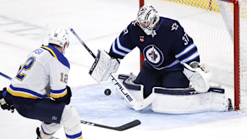 Winnipeg Jets goaltender Connor Hellebuyck blocks a shot from St. Louis Blues center Radek Faksa.