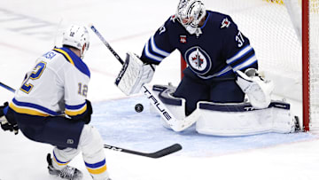 Apr 7, 2025; Winnipeg, Manitoba, CAN; Winnipeg Jets goaltender Connor Hellebuyck (37) blocks a shot from St. Louis Blues center Radek Faksa (12) in the third period at Canada Life Centre. Mandatory Credit: James Carey Lauder-Imagn Images