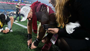 Florida State Seminoles defensive lineman Braden Fiske (55) cuts a piece of the turf after the game. The Florida State Seminoles defeated the Louisville Cardinals 16-6 to claim the ACC Championship title in Charlotte, North Carolina on Saturday, Dec. 2, 2023.