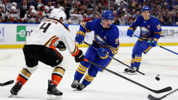 Feb 19, 2024; Buffalo, New York, USA;  Buffalo Sabres left wing Zach Benson (9) flips the puck up ice past Anaheim Ducks defenseman Cam Fowler (4) during the second period at KeyBank Center. Mandatory Credit: Timothy T. Ludwig-USA TODAY Sports