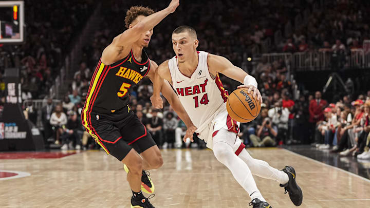 Apr 18, 2025; Atlanta, Georgia, USA; Miami Heat guard Tyler Herro (14) dribbles past Atlanta Hawks guard Dyson Daniels (5) during the second half at State Farm Arena. Mandatory Credit: Dale Zanine-Imagn Images