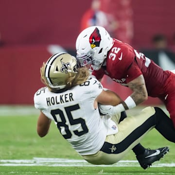 Aug 10, 2024; Glendale, Arizona, USA; New Orleans Saints  tight end Dallin Holker (85) is tackled by Arizona Cardinals safety Joey Blount (32) during a preseason NFL game at State Farm Stadium. Mandatory Credit: Mark J. Rebilas-Imagn Images