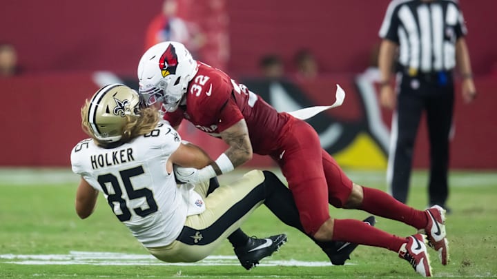 Aug 10, 2024; Glendale, Arizona, USA; New Orleans Saints  tight end Dallin Holker (85) is tackled by Arizona Cardinals safety Joey Blount (32) during a preseason NFL game at State Farm Stadium. Mandatory Credit: Mark J. Rebilas-Imagn Images