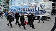Dec 9, 2023; Foxborough, Massachusetts, USA; Members of the US Navy walk by the Navy football team equipment truck at the Army-Navy Game Fan Experience at Gillette Stadium. 