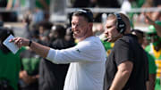 Oregon Head Coach Dan Lanning, left, and Defensive Coordinator Tosh Lupoi discus their game plan during the game against Oklahoma State.