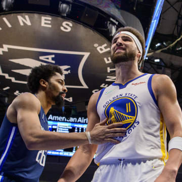 May 22, 2022; Dallas, Texas, USA; Dallas Mavericks guard Spencer Dinwiddie (26) restrains Golden State Warriors guard Klay Thompson (11) as Thompson exchanges words with a  Dallas Mavericks fan during the third quarter in game three of the 2022 western conference finals at American Airlines Center. Mandatory Credit: Jerome Miron-USA TODAY Sports