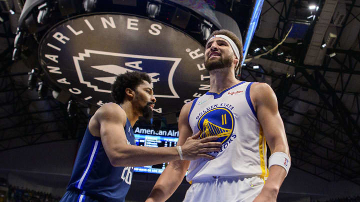 May 22, 2022; Dallas, Texas, USA; Dallas Mavericks guard Spencer Dinwiddie (26) restrains Golden State Warriors guard Klay Thompson (11) as Thompson exchanges words with a  Dallas Mavericks fan during the third quarter in game three of the 2022 western conference finals at American Airlines Center. Mandatory Credit: Jerome Miron-USA TODAY Sports