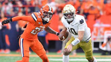 Oct 29, 2022; Syracuse, New York, USA; Notre Dame Fighting Irish quarterback Drew Pyne (10) runs from Syracuse Orange defensive back Justin Barron (23) in the first quarter at JMA Wireless Dome. Mandatory Credit: Mark Konezny-Imagn Images