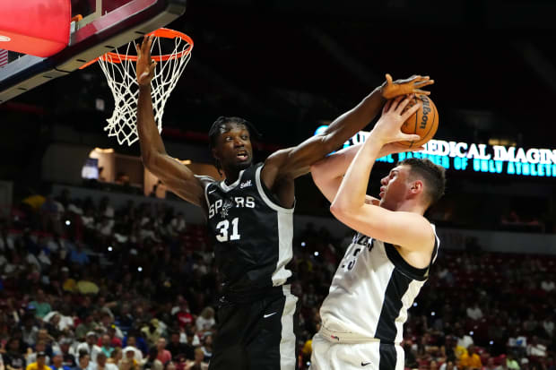 San Antonio Spurs forward Nathan Mensah (31) defends against a shot attempt by Portland Trail Blazers center Donovan Clingan.