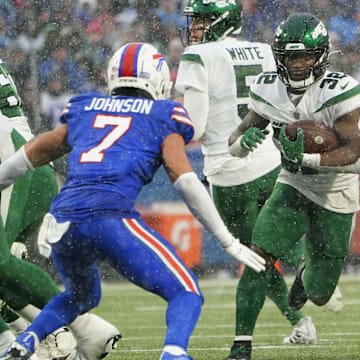 Dec 11, 2022; Orchard Park, New York, USA; New York Jets running back Michael Carter (32) runs with the ball against Buffalo Bills cornerback Taron Johnson (7) during the second half at Highmark Stadium. 