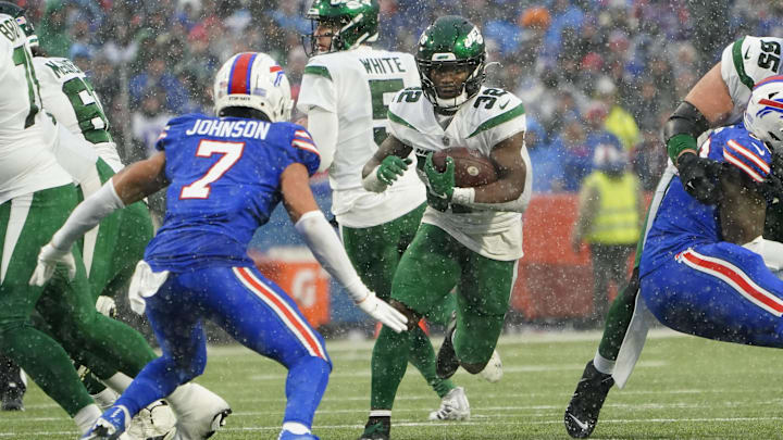 Dec 11, 2022; Orchard Park, New York, USA; New York Jets running back Michael Carter (32) runs with the ball against Buffalo Bills cornerback Taron Johnson (7) during the second half at Highmark Stadium. 