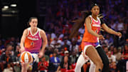 Team WNBA players Caitlin Clark and Angel Reese on the floor against the USA Women's National Team.