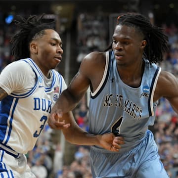 Mar 21, 2025; Raleigh, NC, USA; Duke Blue Devils guard Isaiah Evans (3) defends Mount St. Mary's Mountaineers forward Dola Adebayo (4) during the first half in the first round of the NCAA Tournament at Lenovo Center. Mandatory Credit: Zachary Taft-Imagn Images