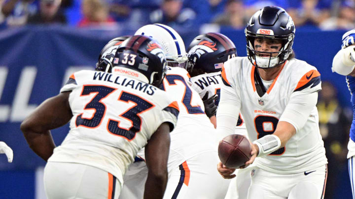 Aug 11, 2024; Indianapolis, Indiana, USA;  Denver Broncos quarterback Jarrett Stidham (8) hands the ball off to Denver Broncos running back Javonte Williams (33) during the first quarter at Lucas Oil Stadium. 