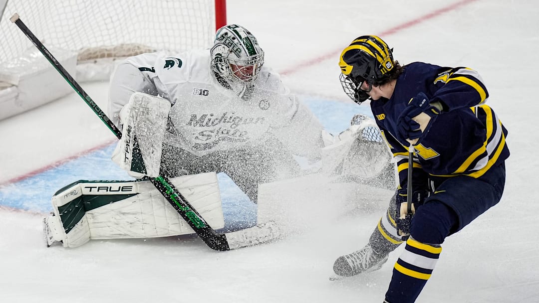 Michigan State goaltender Trey Augustine (1) makes a save against Michigan forward Cole McKinney (11) during the second period of Duel in the D at Little Caesars Arena in Detroit on Saturday, February 7, 2026.