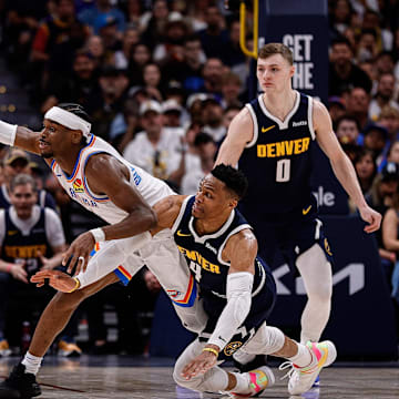 Oklahoma City Thunder guard Shai Gilgeous-Alexander (2) and Denver Nuggets guard Russell Westbrook (4) dive for a loose ball as forward Aaron Gordon (32) and guard Christian Braun (0) look on in the fourth quarter during game four of the second round of the 2025 NBA Playoffs at Ball Arena. Mandatory Credit: Isaiah J. Downing-Imagn Images