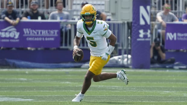 Oregon Ducks quarterback Dante Moore (5) runs the ball past Northwestern Wildcats defensive lineman Anto Saka (4