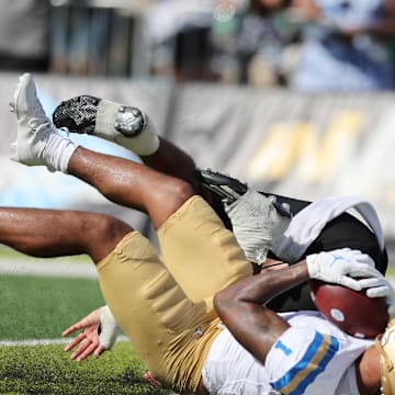 Aug 31, 2024; Honolulu, Hawaii, USA; UCLA Bruins wide receiver Rico Flores Jr. (1) pulls in a catch for a touchdown over Hawaii Rainbow Warriors defensive back Peter Manuma (1) during the third quarter of an NCAA college football game against the UCLA Bruins at the Clarence T.C. Ching Athletics Complex. Mandatory Credit: Marco Garcia-Imagn Images