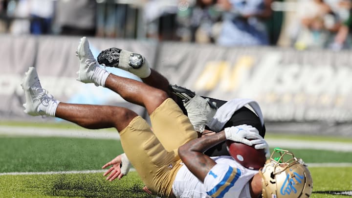 Aug 31, 2024; Honolulu, Hawaii, USA; UCLA Bruins wide receiver Rico Flores Jr. (1) pulls in a catch for a touchdown over Hawaii Rainbow Warriors defensive back Peter Manuma (1) during the third quarter of an NCAA college football game against the UCLA Bruins at the Clarence T.C. Ching Athletics Complex. Mandatory Credit: Marco Garcia-Imagn Images