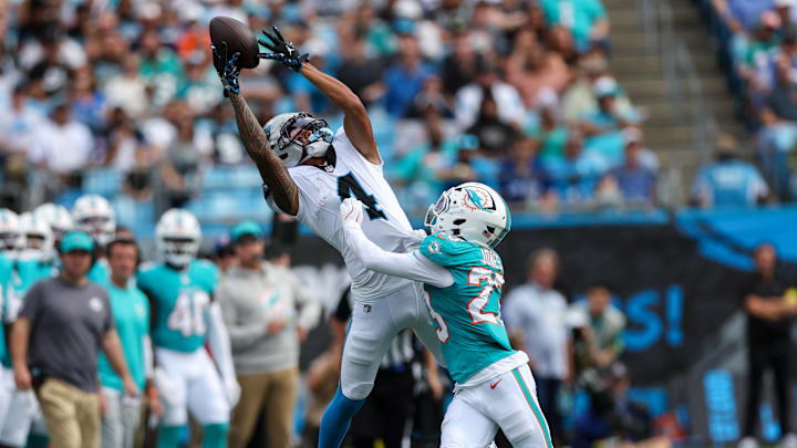 Carolina Panthers wide receiver Tetairoa McMillan (4) reaches for a pass with Miami Dolphins cornerback Jack Jones (23) defending during the third quarter at Bank of America Stadium.