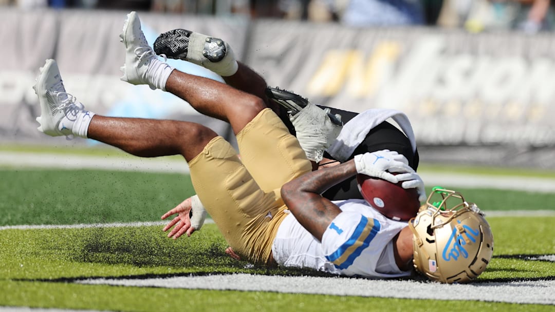 Aug 31, 2024; Honolulu, Hawaii, USA; UCLA Bruins wide receiver Rico Flores Jr. (1) pulls in a catch for a touchdown over Hawaii Rainbow Warriors defensive back Peter Manuma (1) during the third quarter of an NCAA college football game against the UCLA Bruins at the Clarence T.C. Ching Athletics Complex. Mandatory Credit: Marco Garcia-Imagn Images