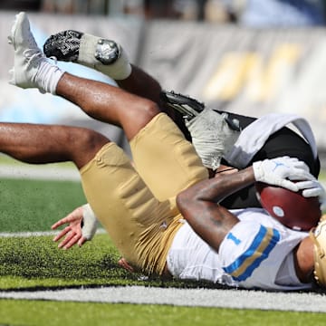 Aug 31, 2024; Honolulu, Hawaii, USA; UCLA Bruins wide receiver Rico Flores Jr. (1) pulls in a catch for a touchdown over Hawaii Rainbow Warriors defensive back Peter Manuma (1) during the third quarter of an NCAA college football game against the UCLA Bruins at the Clarence T.C. Ching Athletics Complex. Mandatory Credit: Marco Garcia-Imagn Images