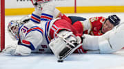 Dec 30, 2024; Sunrise, Florida, USA;  New York Rangers goaltender Igor Shesterkin (31) loses possession of the puck as Florida Panthers center Carter Verhaeghe (23) falls on top of him during the second period at Amerant Bank Arena. Mandatory Credit: Jim Rassol-Imagn Images